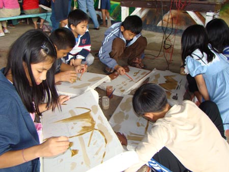 THERAPY. This kids from Kayan, Tadian, Mt. Province shared their experiences from the deadly Typhoon "Pepeng" that killed many of their classmates and friends by painting their canvasses with art designs using soil. Photo Courtesy of DKK