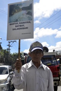 REMINDING THE YOUNG. With a placard saying it all, this old man joined the march protest demanding the respect of the rights of the people over their agricultural and ancestral lands. Photo by Aldwin Quitasol