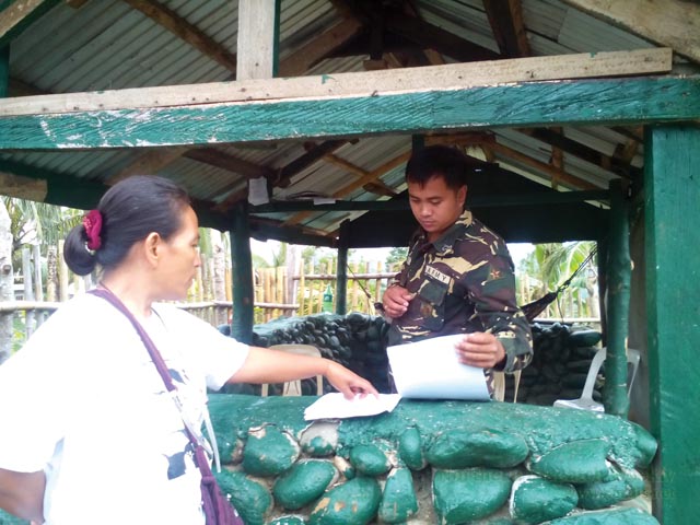 A soldier on post skims the peoples'  declaration. He hesitantly called for the officers to decide if the paper will be received or not. Photo by Alma B. Sinumlag